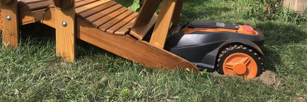 Mo, the robotic lawnmower, dug in behind Adirondack chair